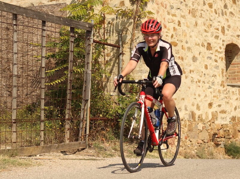 Cyklist kører på landevej ved stenmur
