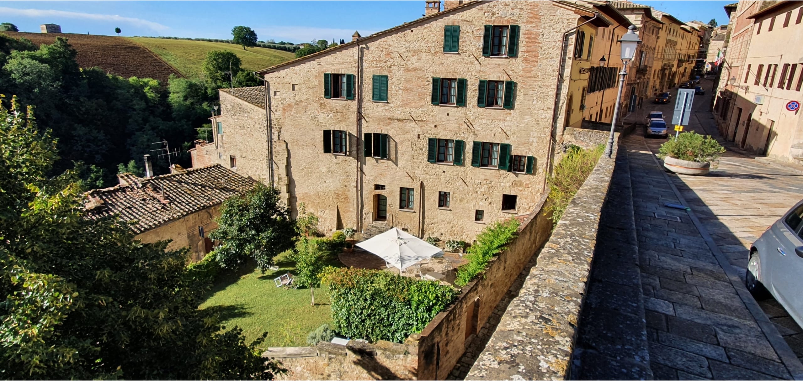 Historisk by med stenhuse og grønne bakker