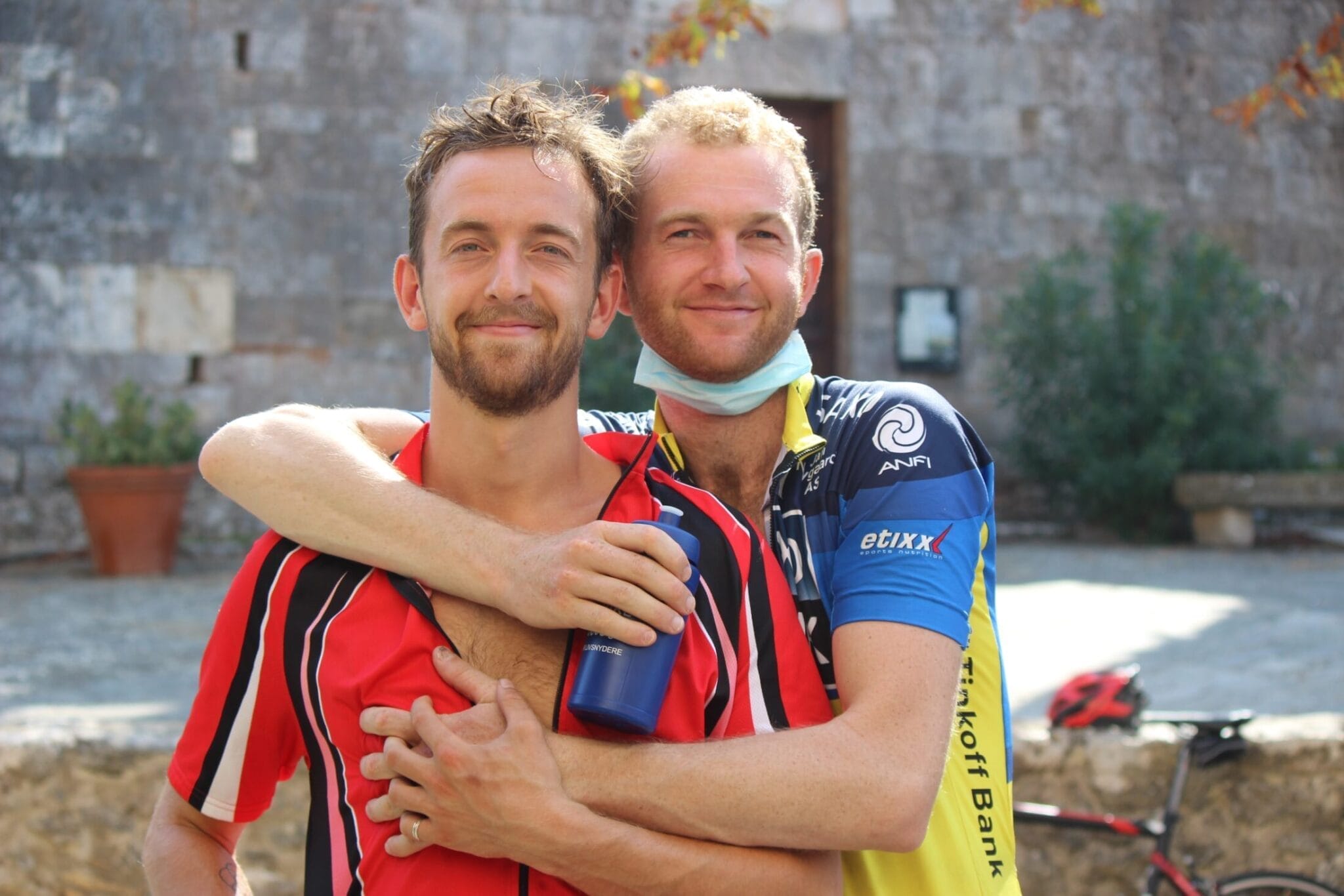 To cyklister smiler og krammer udendørs